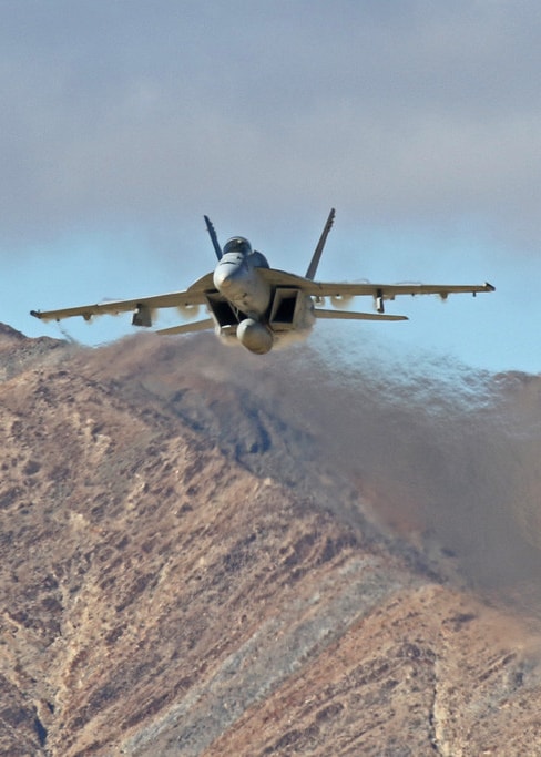 Fighter Jet flying with the desert behind